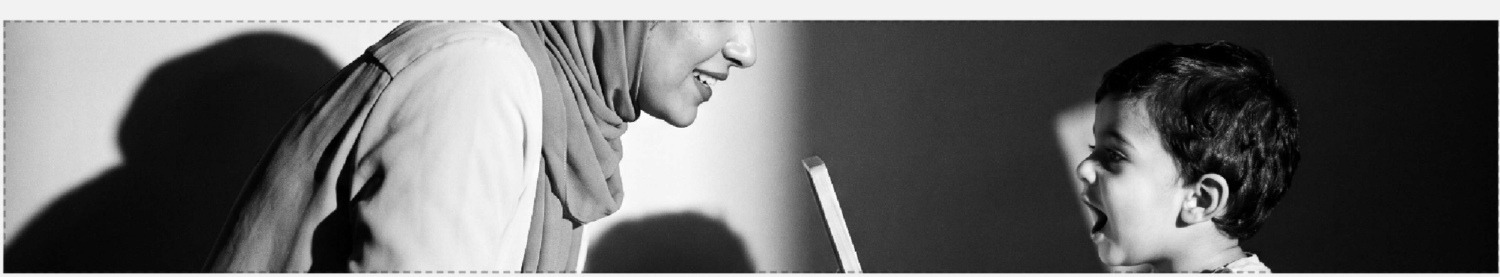 أم تجلس مقابل طفلها في جلسة تدريب نطق ولغة